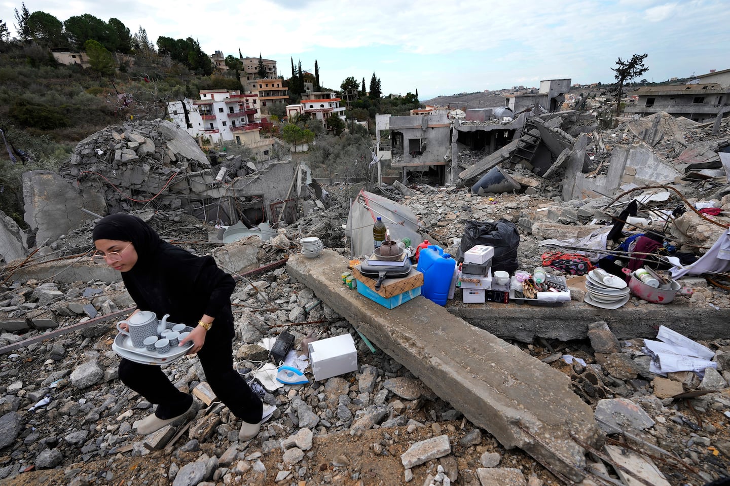 A woman collects the remains of her destroyed house after she returned to Chehabiyeh village, southern Lebanon, Nov. 28, following a ceasefire between Israel and Hezbollah that went into effect on Wednesday.