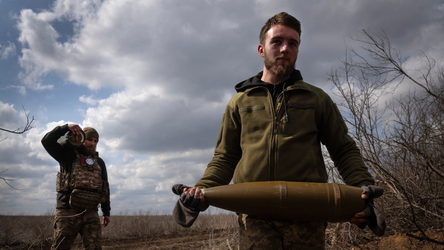 Ukrainian soldiers carry shells to fire at Russian positions on the front line, near the city of Bakhmut, in Ukraine's Donetsk region, on March 25.