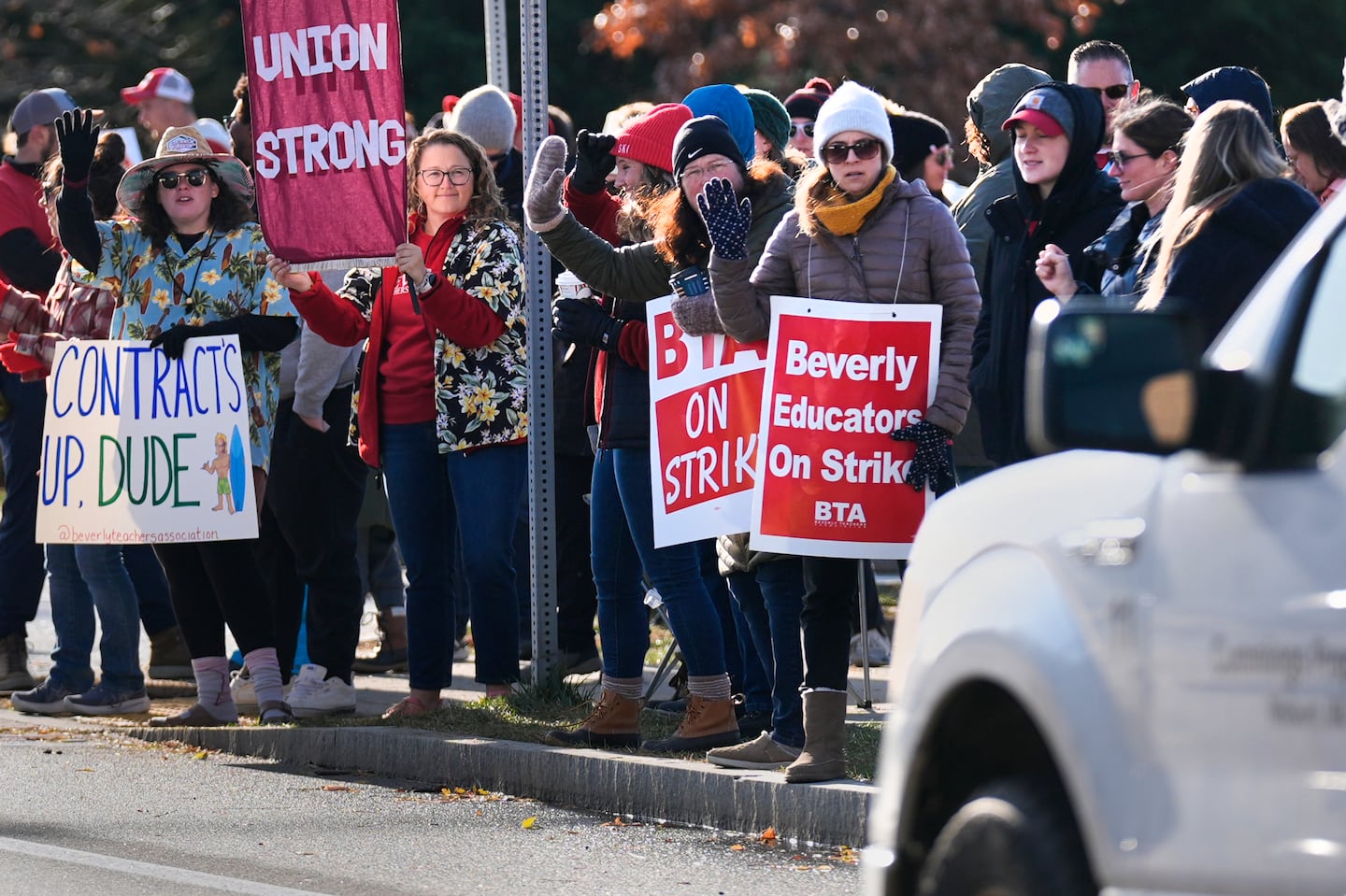 Striking teachers and supporters stood on the picket line Friday in Beverly to call attention to pay, paid parental leave, and other contract issues.