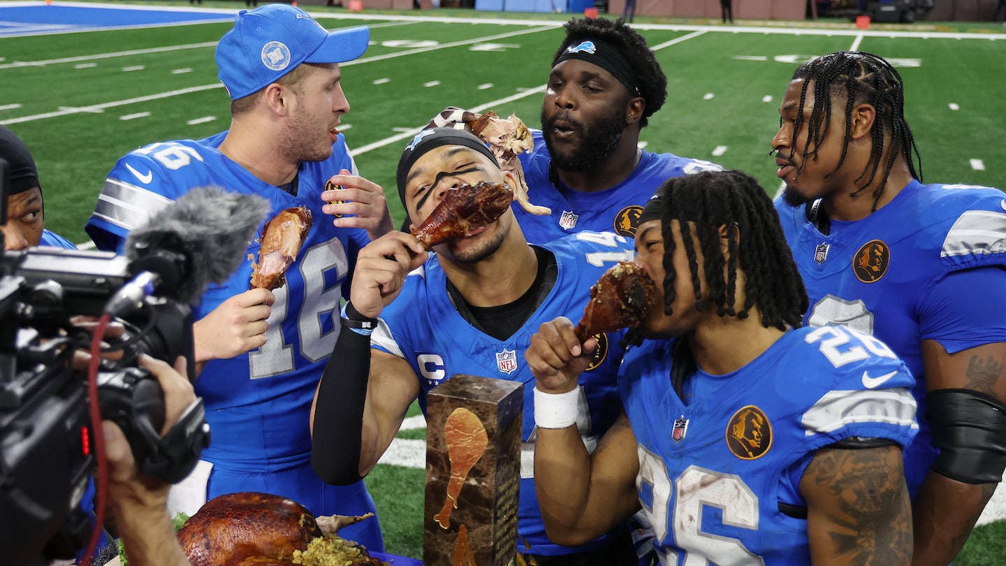 The Lions celebrate and eat turkey during an interview after beating the Bears for their 10th straight victory.