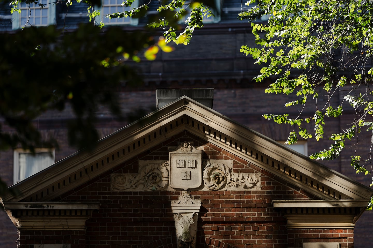 Harvard University’s logo and motto on a campus building in Cambridge.