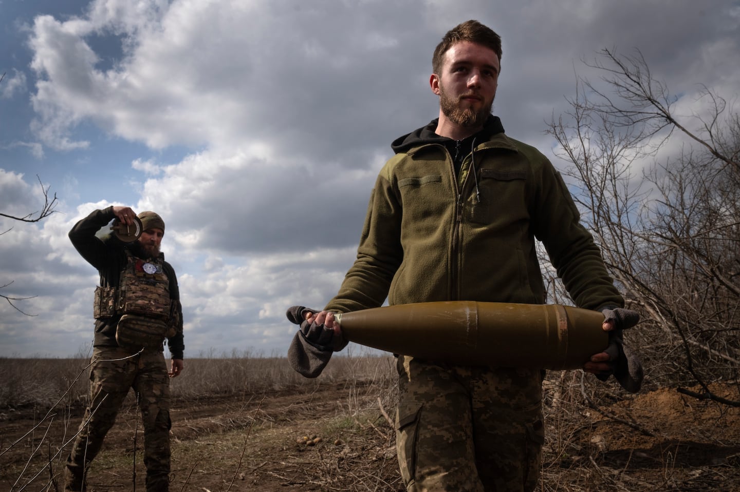 Ukrainian soldiers carry shells to fire at Russian positions on the front line, near the city of Bakhmut, in Ukraine's Donetsk region, on March 25.