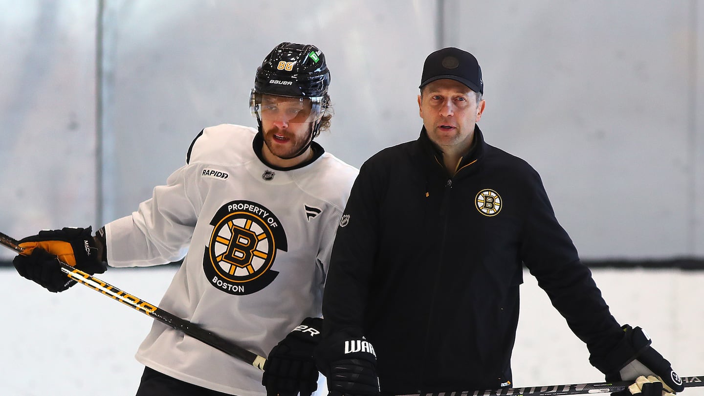 Bruins coach Joe Sacco (right) does not sound concerned about the production of the usually high-scoring David Pastrnak (left).