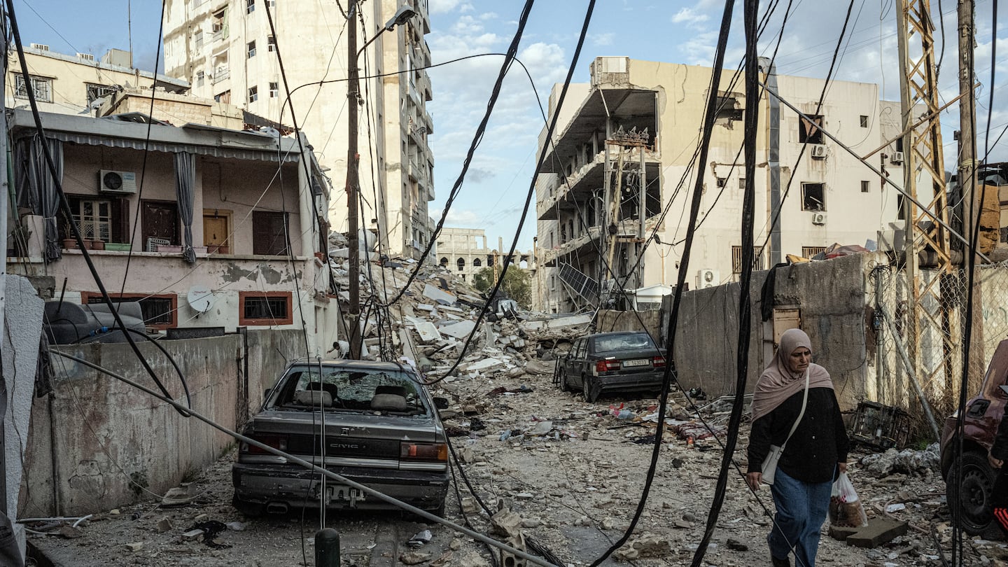 A woman walked past war-damaged buildings in a residential neighborhood in Tyre,  Lebanon, on Friday, Nov. 29, 2024. The Israeli military issued new warnings to the residents of towns on both sides of the Israel-Lebanon border on Friday, telling them not to return to their homes, as the fragile US-brokered cease-fire between Israel and Hezbollah appeared to largely hold despite another Israeli strike in southern Lebanon.