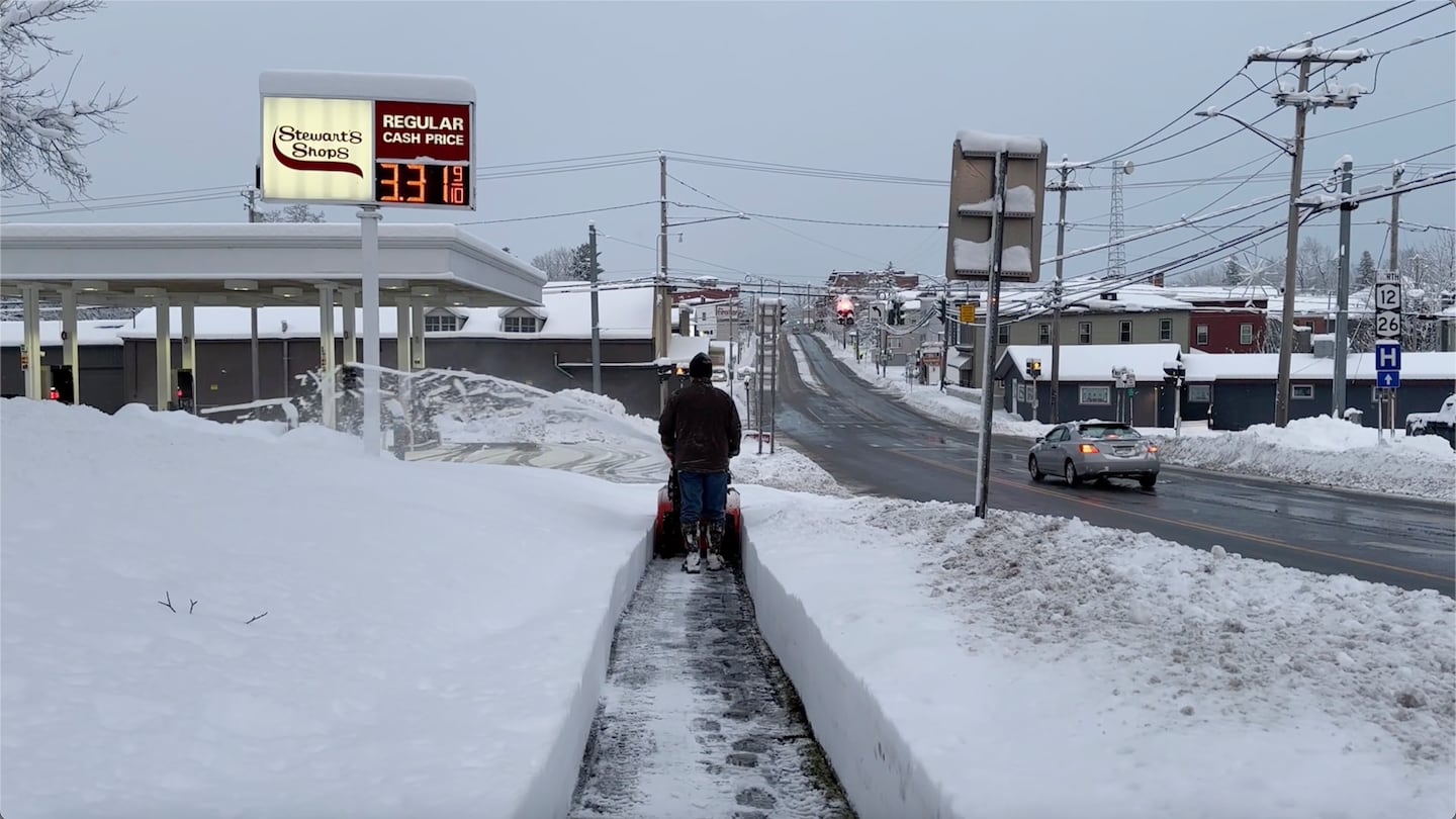 A person cleared the snow from the sidewalk in Lowville, N.Y., on Saturday.