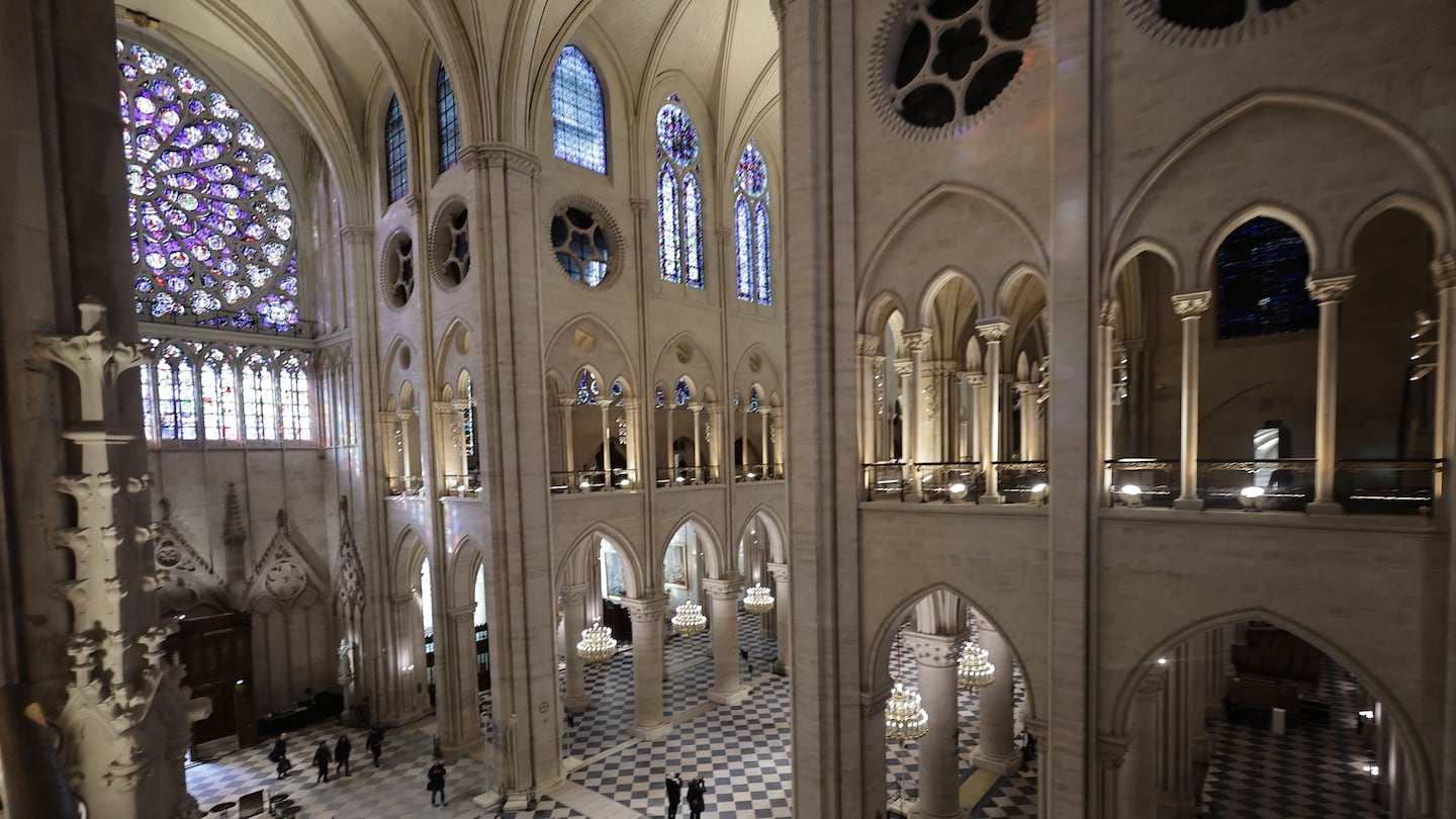 People stroll in Notre-Dame de Paris cathedral while French President Emmanuel Macron visited the restored interiors the monument, on Friday, in Paris.