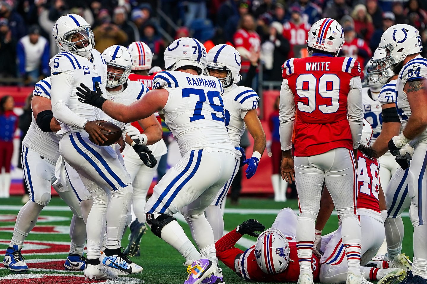 Anthony Richardson (left) gets swarmed by his teammates after getting into the end zone for the two-point conversion to put the Colts ahead.