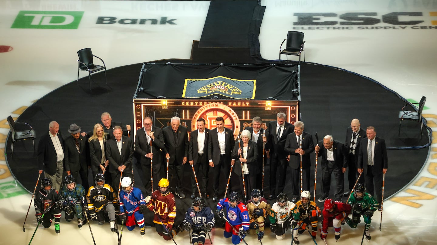 Bruins legends and youth hockey players pose for a photo before Sunday's Centennial Game.