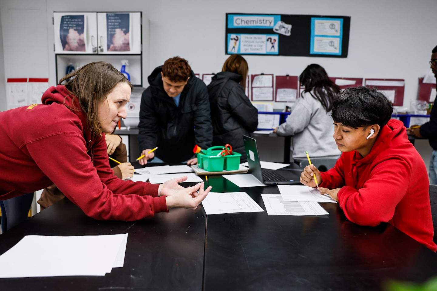 Science teacher Jamie Kendall provides one-on-one guidance to Gender, 17, during class at Chelsea Opportunity Academy. Chelsea Public Schools requires all high school students to take a rigorous course load, including lab-based science classes, in order to graduate.