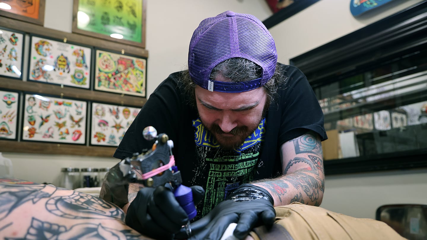 Chris Coulon, a.k.a. Tallboy, works on a client's tattoo at North Street Tattoo in Salem.