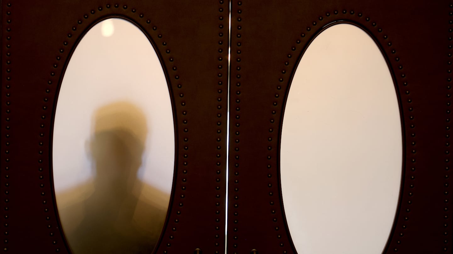 A Senate aide was silhouetted against the door leading to the Senate chambers on what was scheduled to be the final day of the Legislature's formal sessions in July.