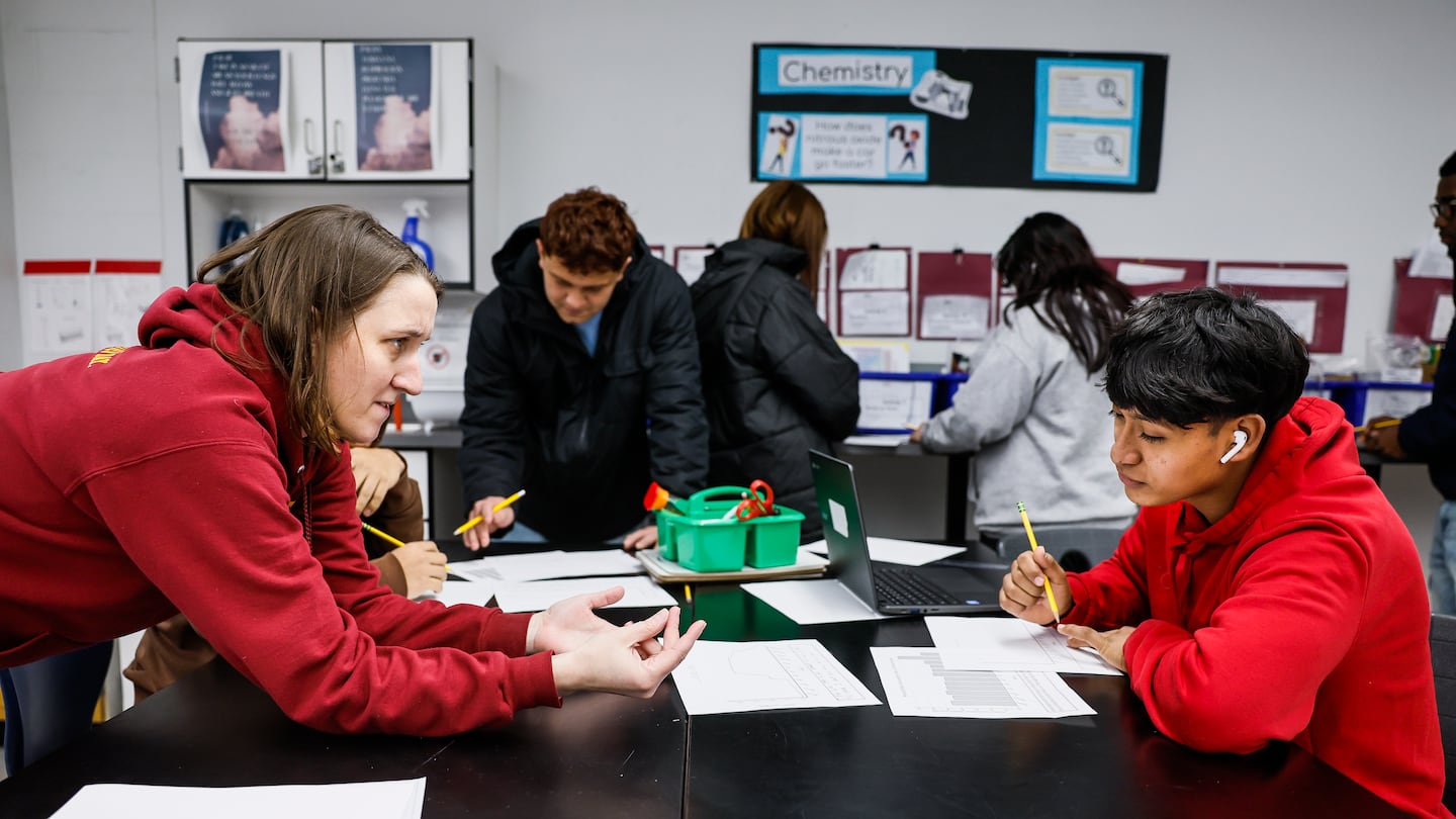 Science teacher Jamie Kendall provided one-on-one guidance to Gender, 17, during class at Chelsea Opportunity Academy. Chelsea Public Schools requires all high school students to take a rigorous course load, including lab-based science classes, in order to graduate.