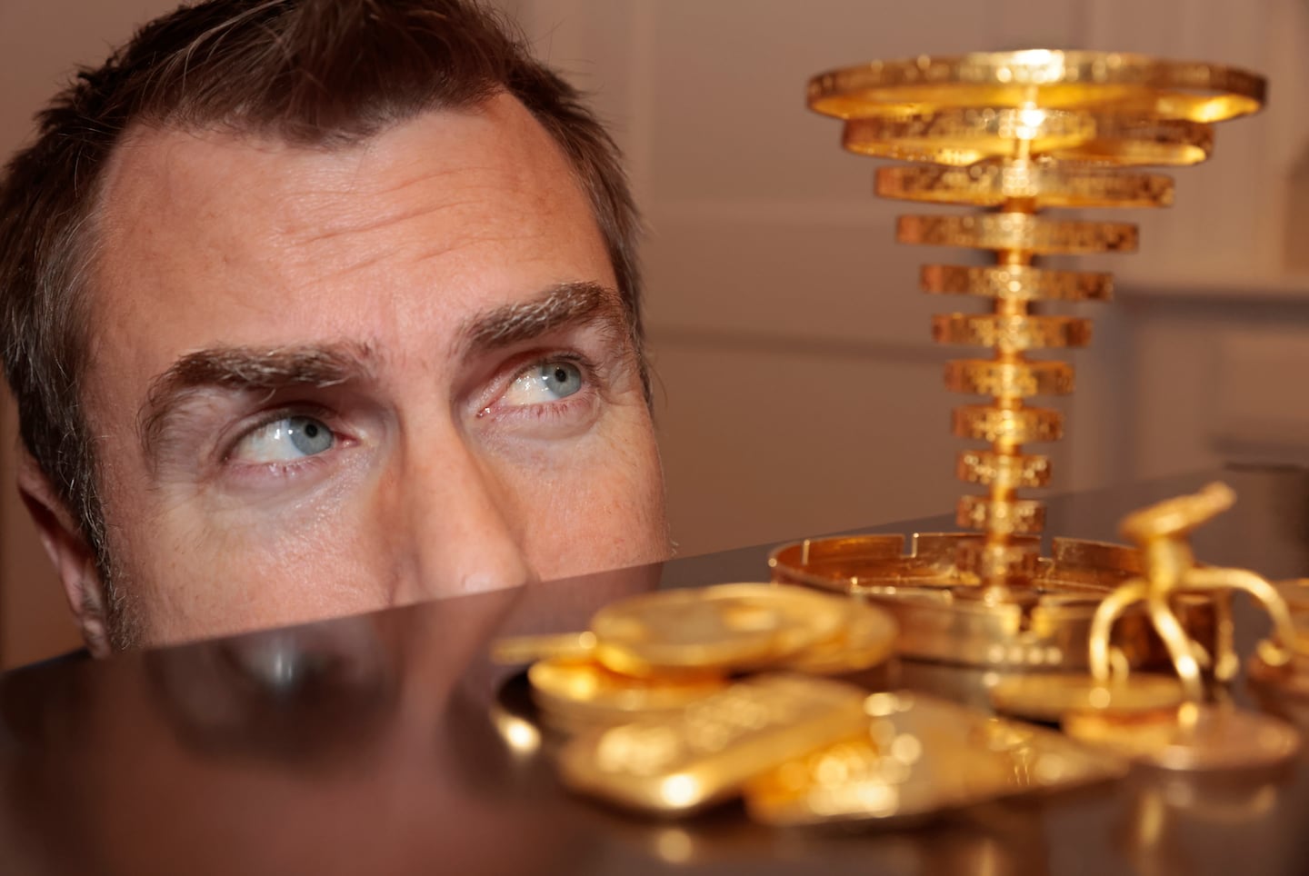 Meteorologist Dan Leonard posed with the golden trophy he located in the woods during the initial Project Skydrop treasure hunt and the $87,600 prize in gold coins.