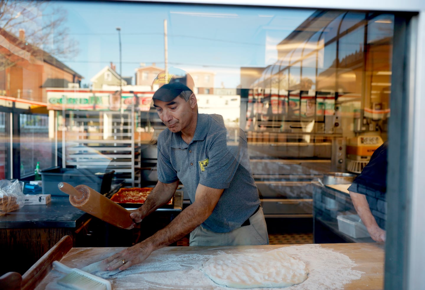 Matt Zappala shaped pizza dough at his family-run business, Tripoli Bakery and Pizza in Lawrence, which celebrates its 100th year in business this year.