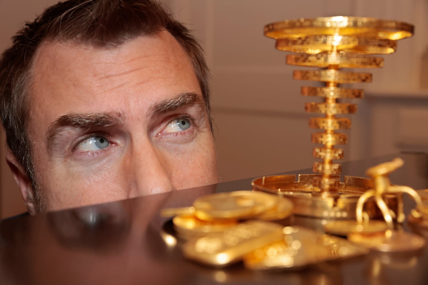 Meteorologist Dan Leonard posed with the golden trophy he located in the woods during the initial Project Skydrop treasure hunt and the $87,600 prize in gold coins.