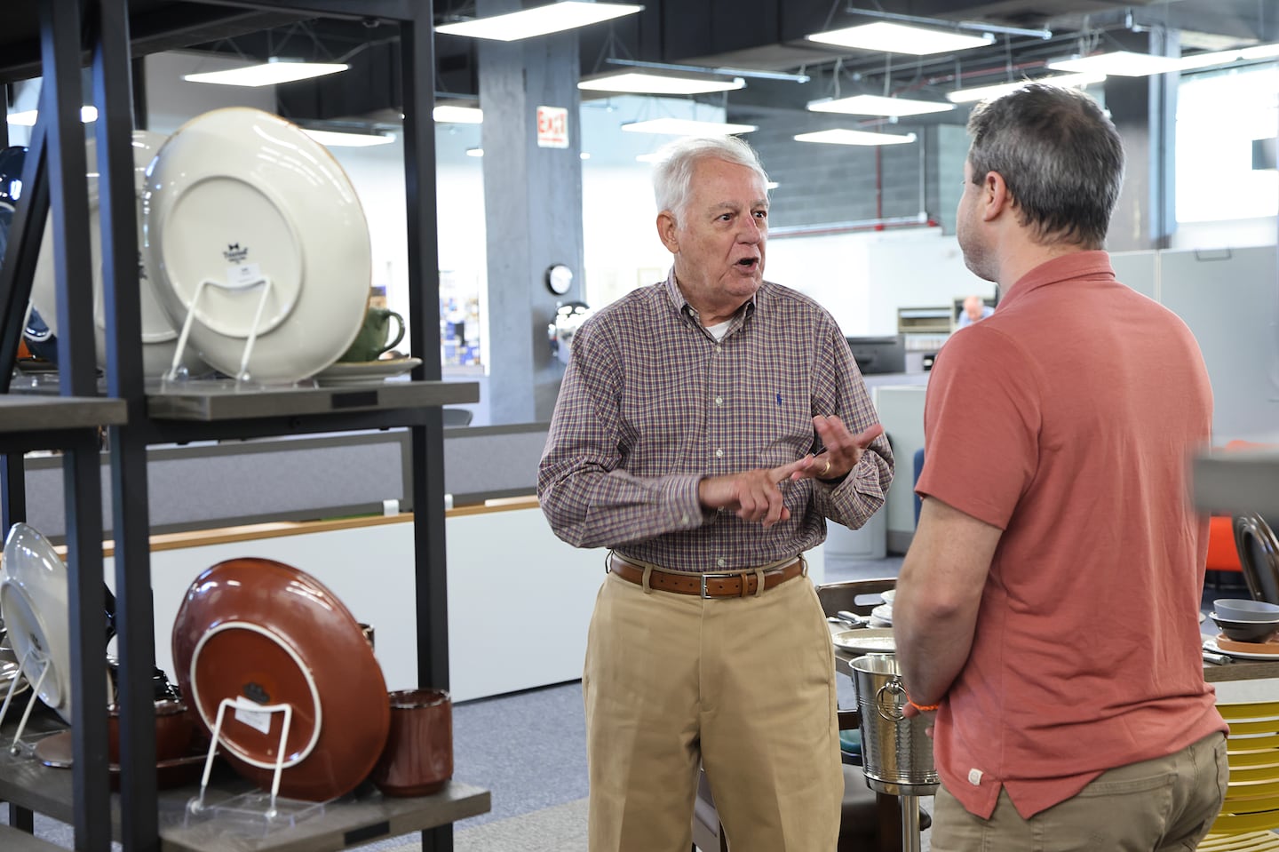 Frank Valdes (left) talks with Boston Showcase CEO Andy Starr in the Boston Showcase warehouse. Valdes is part of a wave of employees remaining on the job past the traditional retirement age of 65.