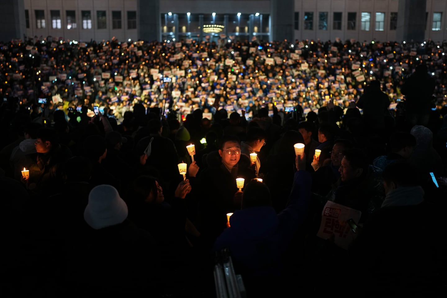 Demonstrators calling on President Yoon Suk Yeol to step down after his brief imposition of martial law in South Korea hold a candlelight vigil outside the National Assembly building in Seoul on Thursday, Dec. 5, 2024.