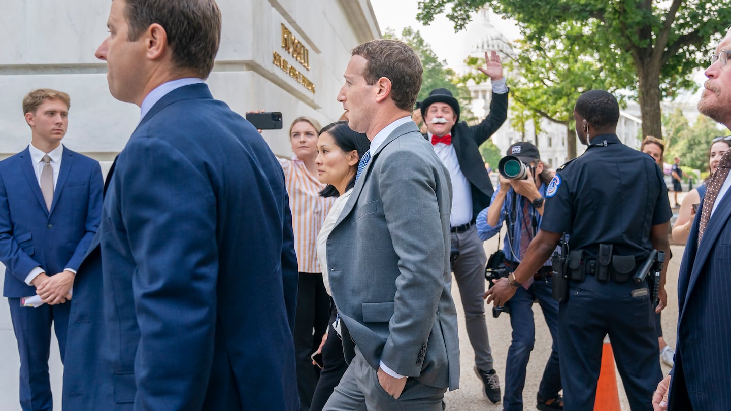 Meta CEO Mark Zuckerberg passes media and a protester as he arrives for a closed-door gathering of leading tech CEOs to discuss the priorities and risks surrounding artificial intelligence, on Capitol Hill in Washington, on Sept. 13, 2023.