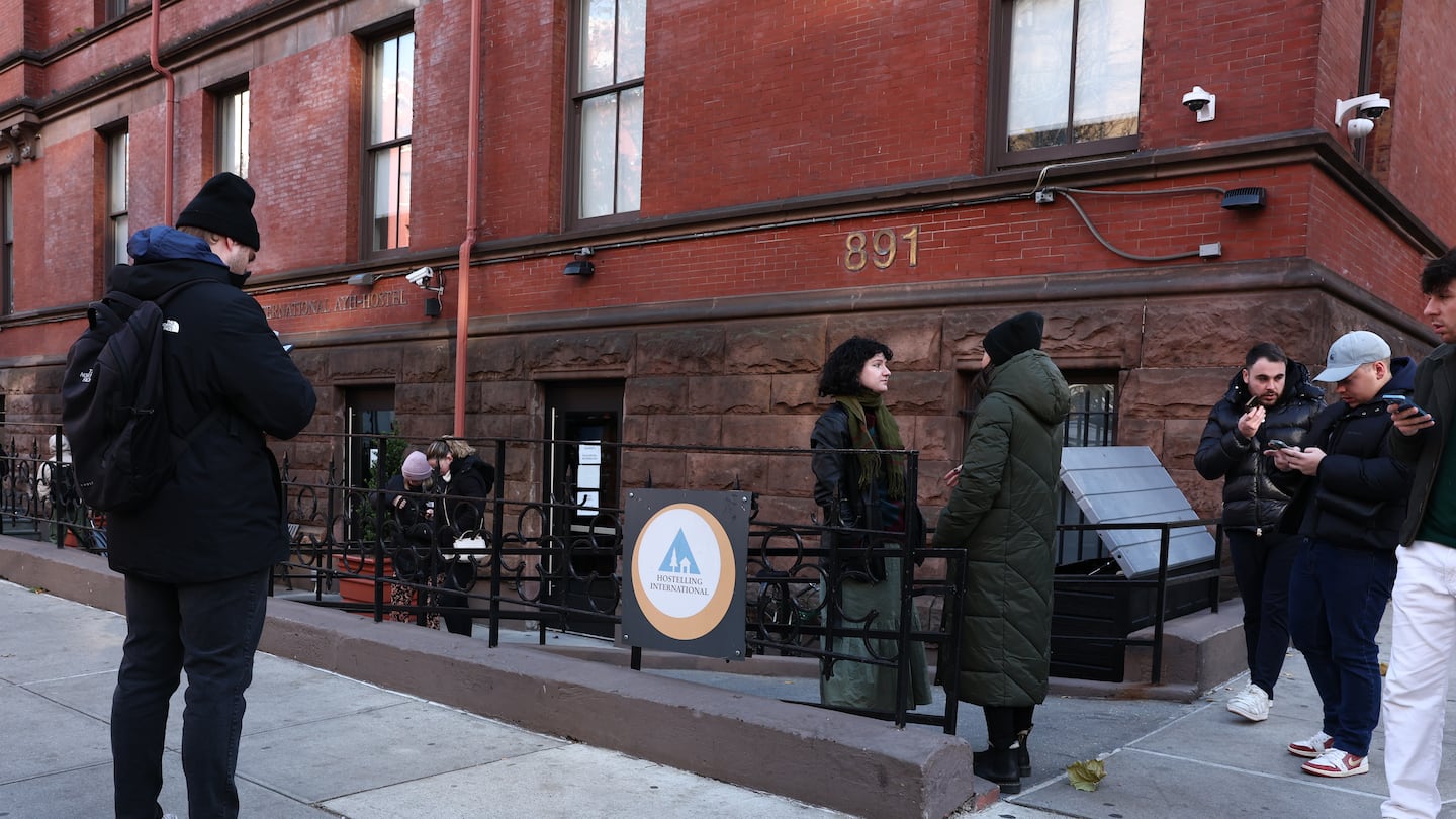 People hang out outside of the HI New York City Hostel on Dec. 6, 2024 in New York City.