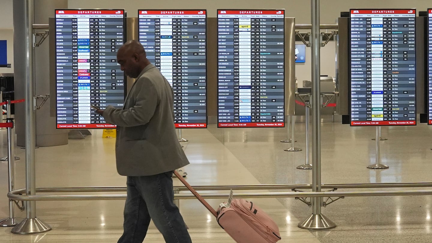 A traveler walks to his gate at Miami International Airport, Tuesday, Nov. 26, 2024, in Miami.