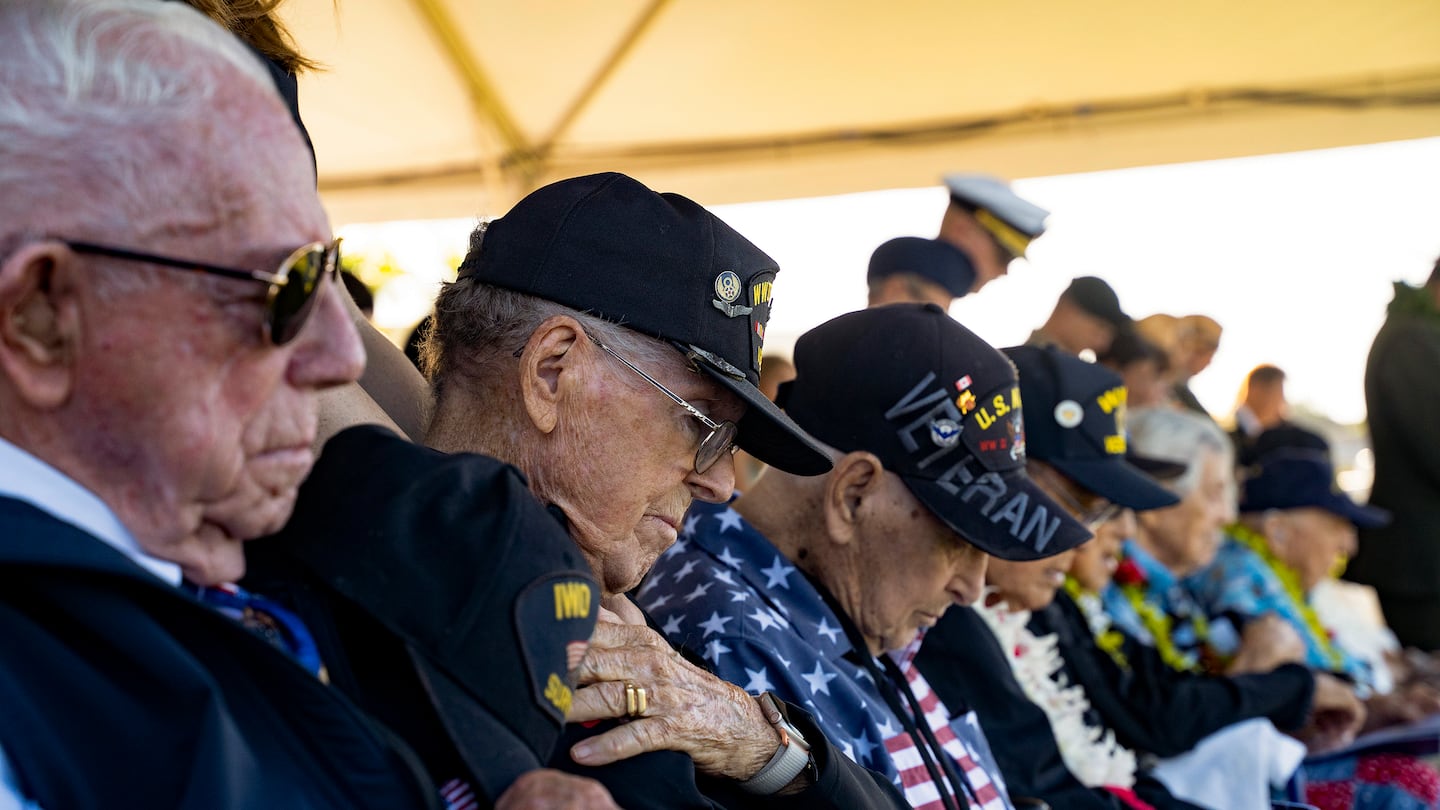 World War II veterans bow their heads during a prayer for the 83rd Pearl Harbor Remembrance Day ceremony Saturday.