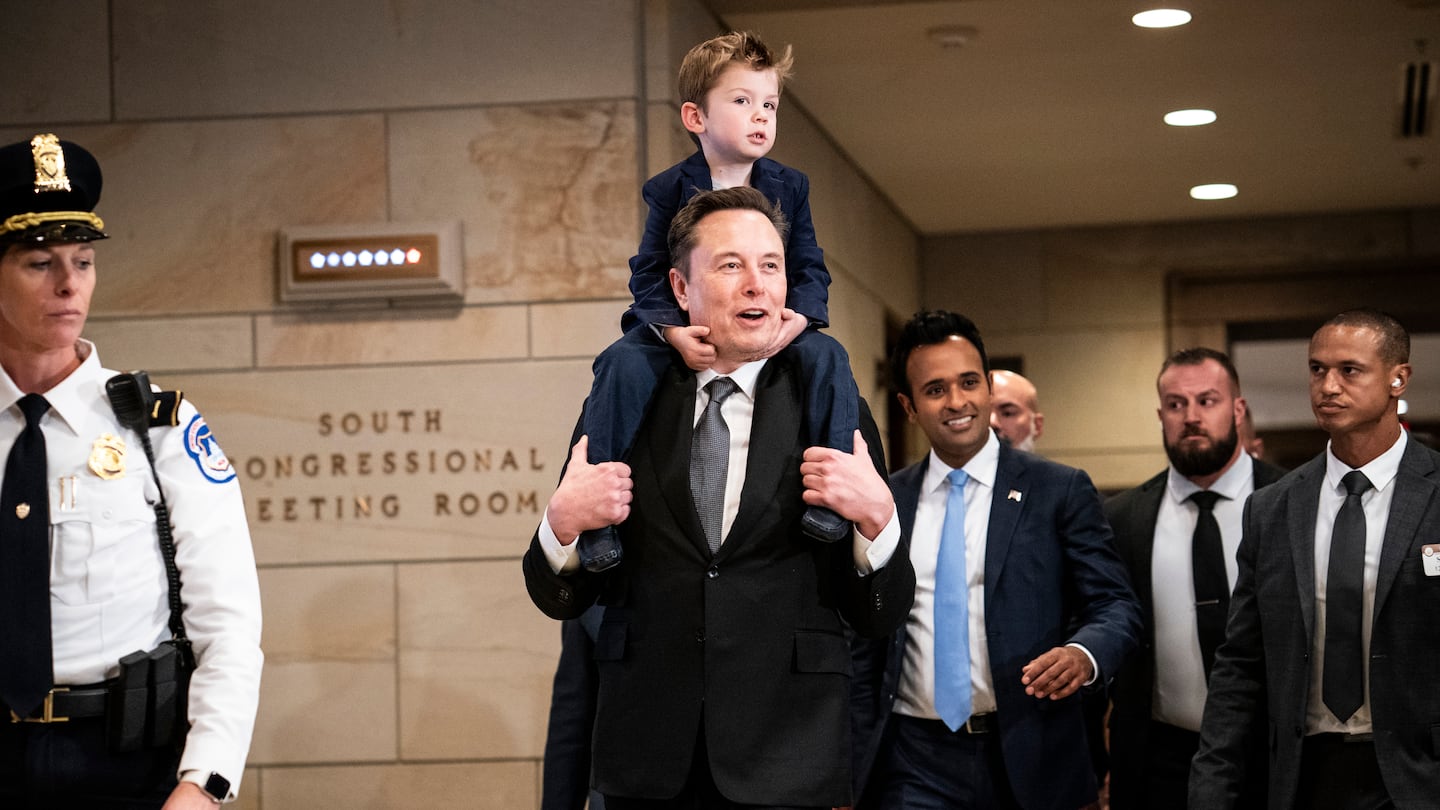 Elon Musk, carrying his son, arrived with Vivek Ramaswamy, third from right, for a meeting on Capitol Hill in Washington, on Thursday.