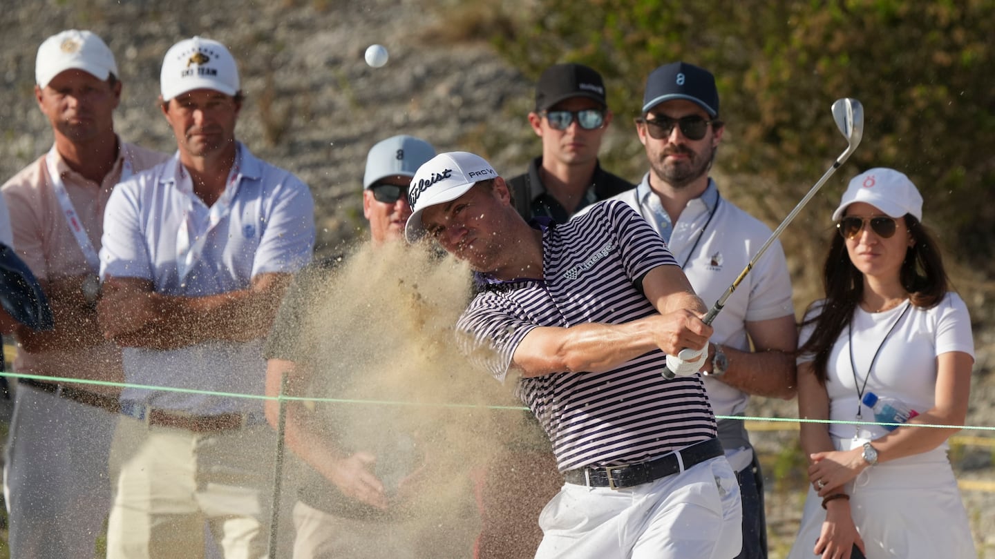 Justin Thomas, front, of the United States, watches his shot from the trap on the 16th hole during the third round of the Hero World Challenge Saturday at the Albany Golf Club in New Providence, Bahamas.