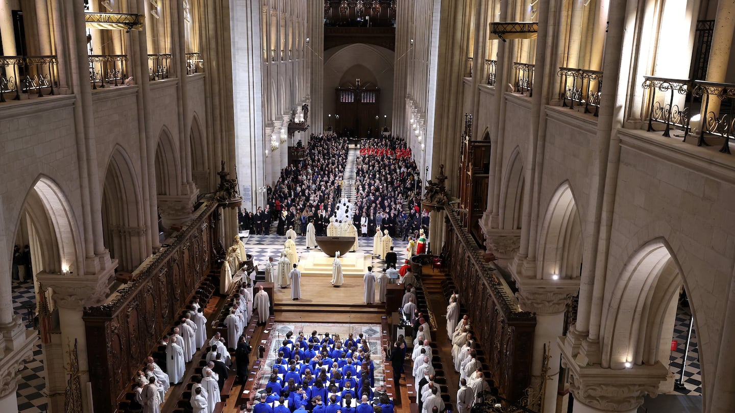 The choir, Clergy, and guests stand during the ceremony to mark the reopening of Notre-Dame of Paris Cathedral on Saturday in Paris, France. 