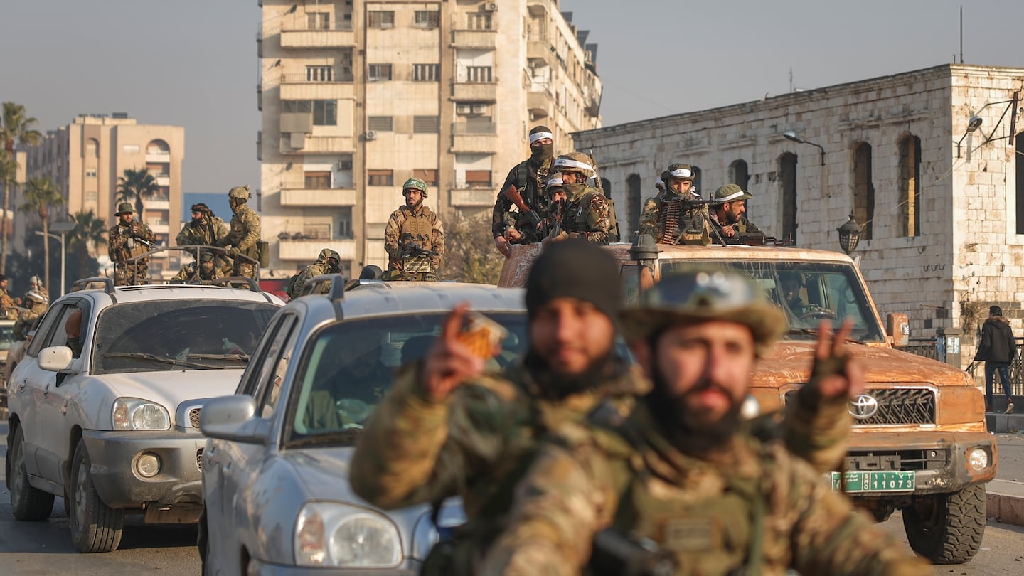 Syrian opposition fighters ride along the streets in the aftermath of the opposition's takeover of Hama, Syria, on Friday, 