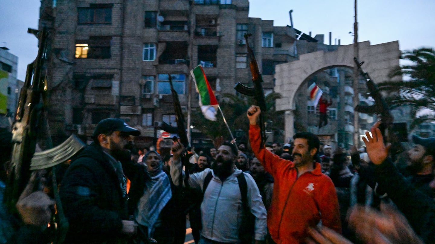 Local residents cheered as they gather on a street in the Damascus suburb of Jaramana on Sunday. Syrian rebels said on Sunday that President Bashar al-Assad had fled the country, calling on citizens abroad to return to a "free Syria" and saying that Damascus was free of the "tyrant."