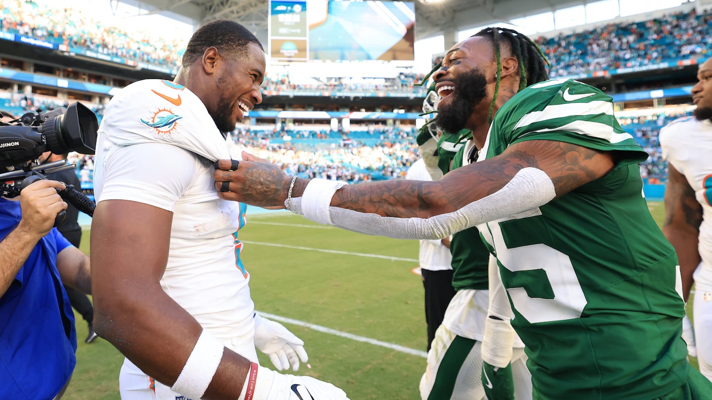 Despite his team being on the wrong end of the heroics by the Dolphins, the Jets' Jalen Mills (right) shared a light moment with former Patriots teammate Jonnu Smith.