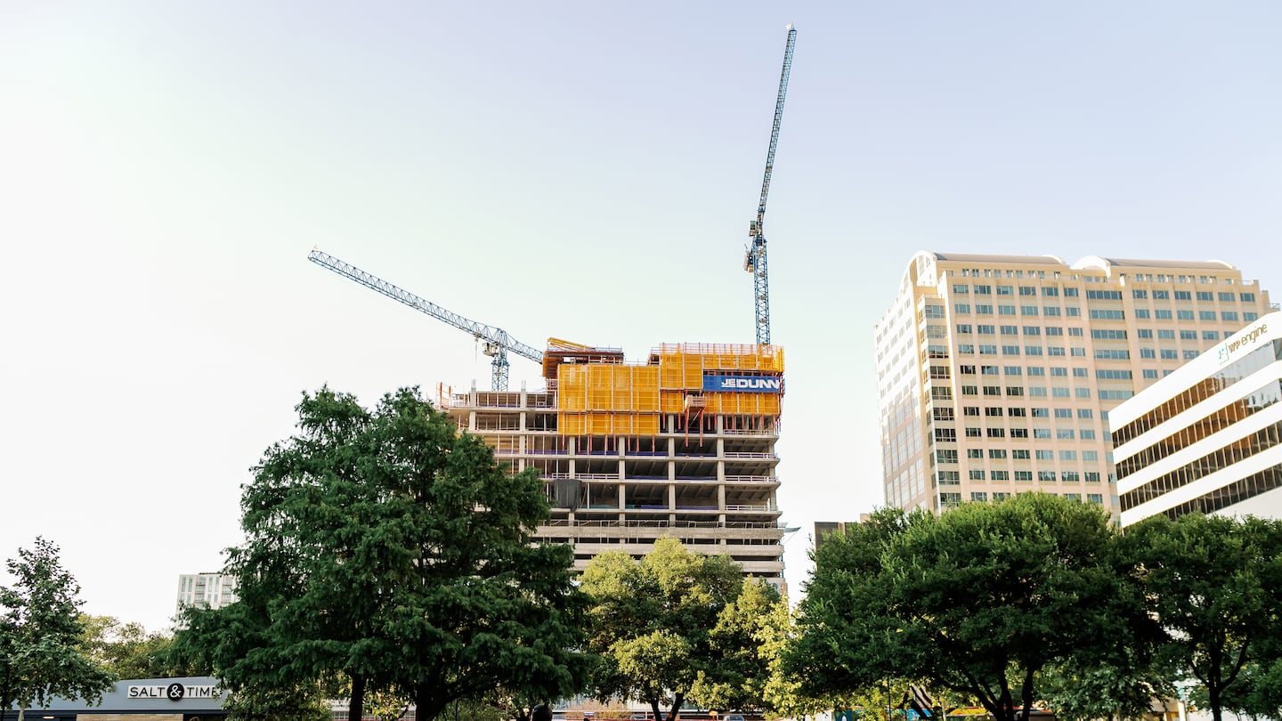 A yoga class takes place in front of construction in Austin, Texas, June 17, 2021.