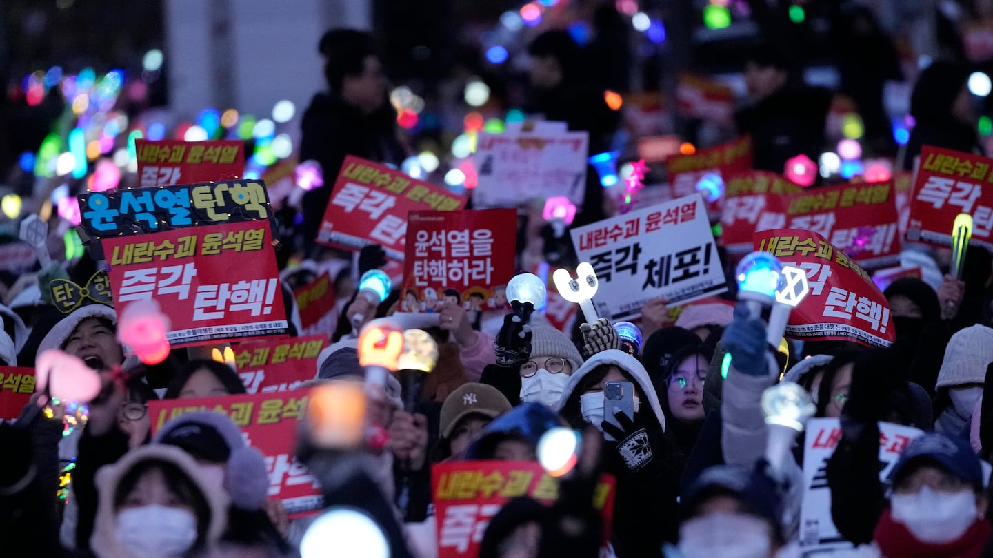 Participants attend a rally demanding South Korean President Yoon Suk Yeol's impeachment outside the National Assembly in Seoul, South Korea, on Dec. 8. The signs read "Impeach Yoon Suk Yeol."