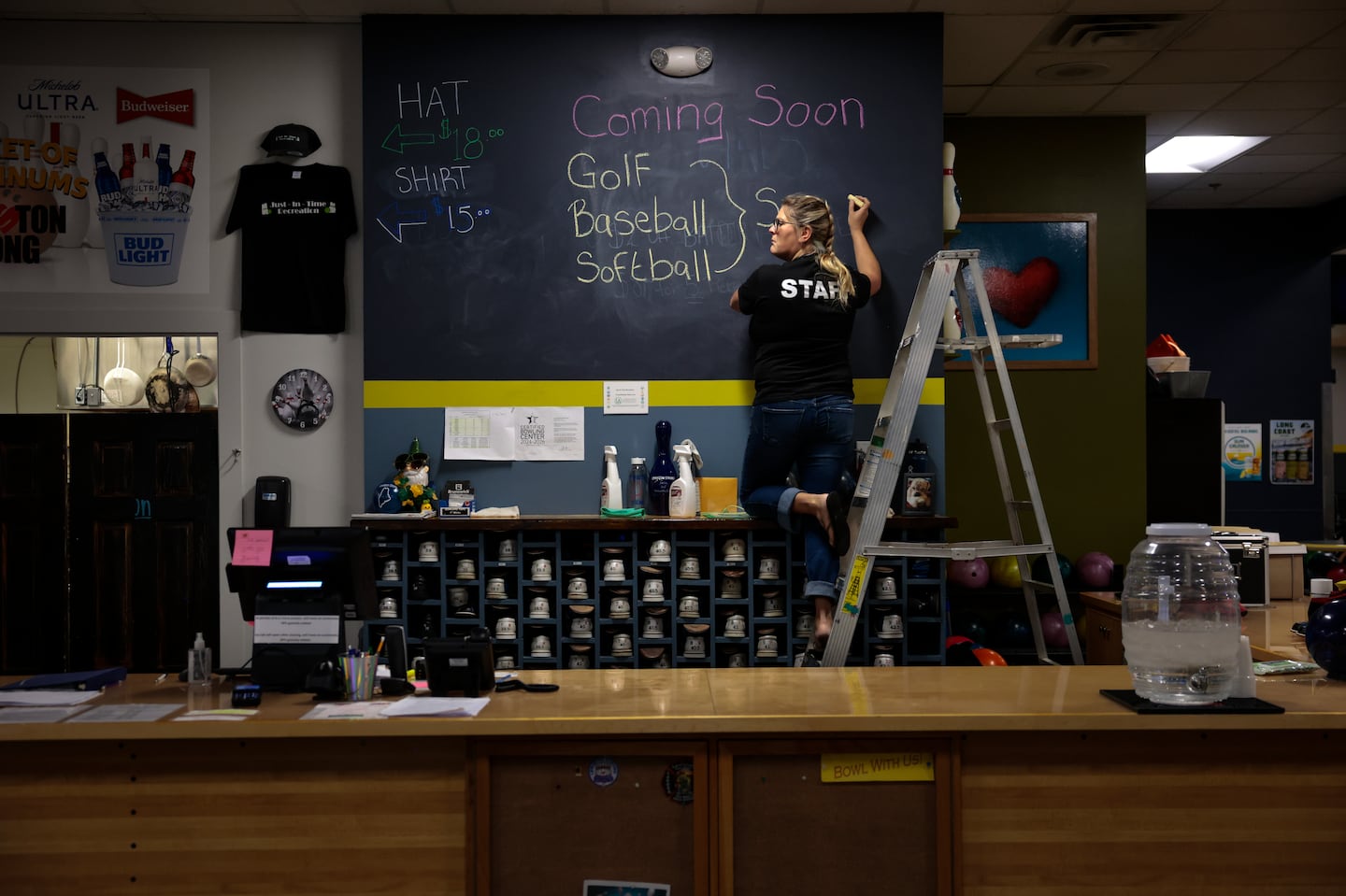 Owner Samantha Juray added a  promotion to a blackboard at the front desk at Just-In-Time Recreation in Lewiston, Maine on Oct. 2. The bowling alley was devastated on Oct. 25, 2023, the night of the state’s deadliest mass shooting that claimed 18 lives at the Just-In-Time and Schemengees Bar & Grille.