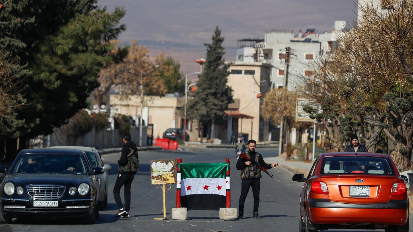 Syrian opposition fighters man a checkpoint in Damascus, Syria, on Dec. 9.