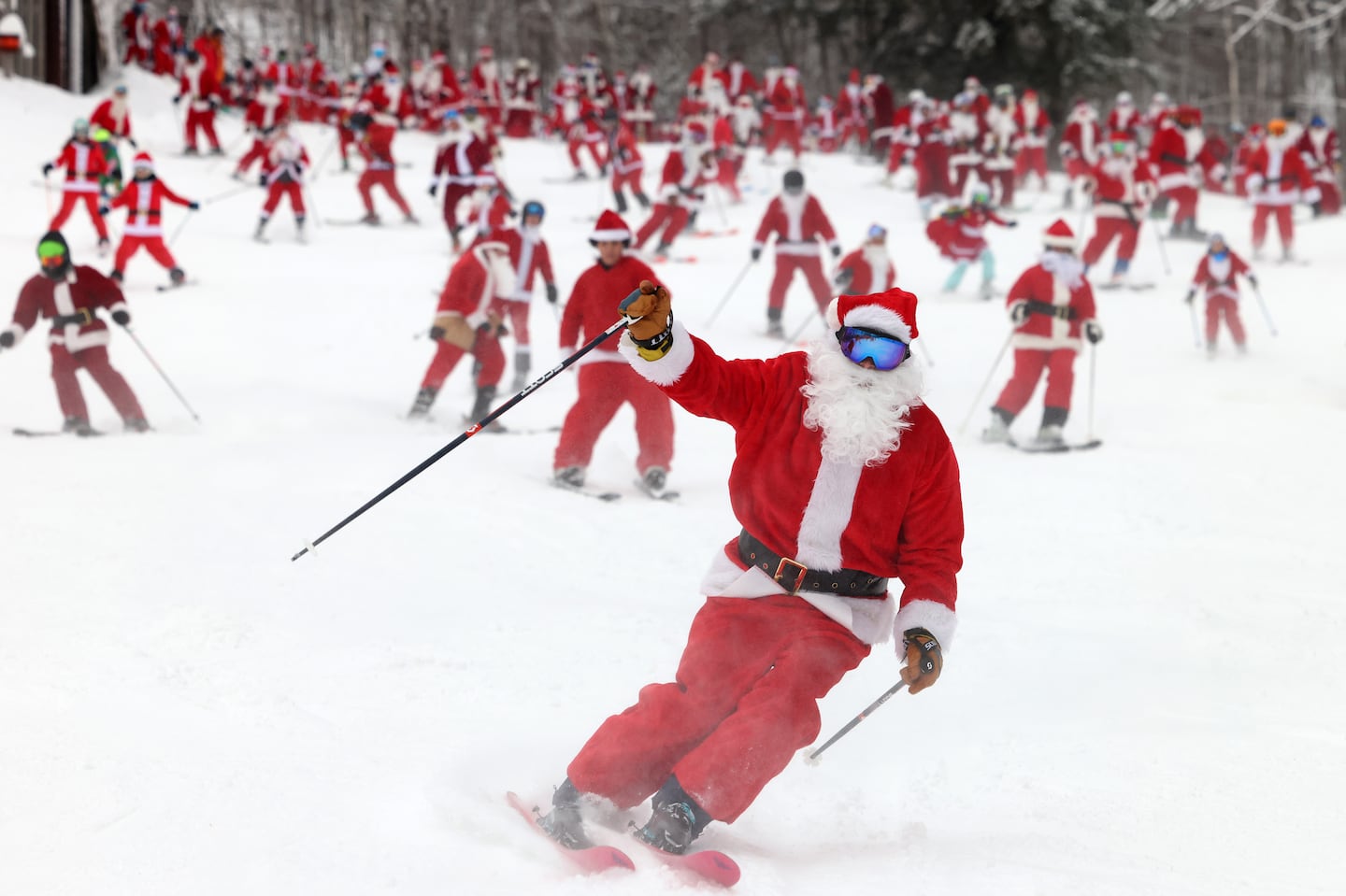 Hundreds of skiers and snowboarders dressed up as Santa and skied down the mountain together during Santa Sunday at Sunday River.