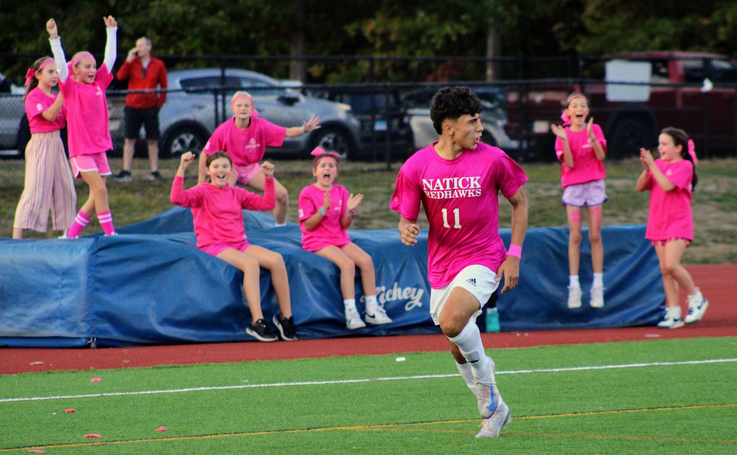 Members of the Natick Youth Soccer League cheer for Natick senior Joel Duarte after he scored the decisive go-ahead goal late in a 2-1 victory over visiting Dover-Sherborn on Oct. 4, 2024.