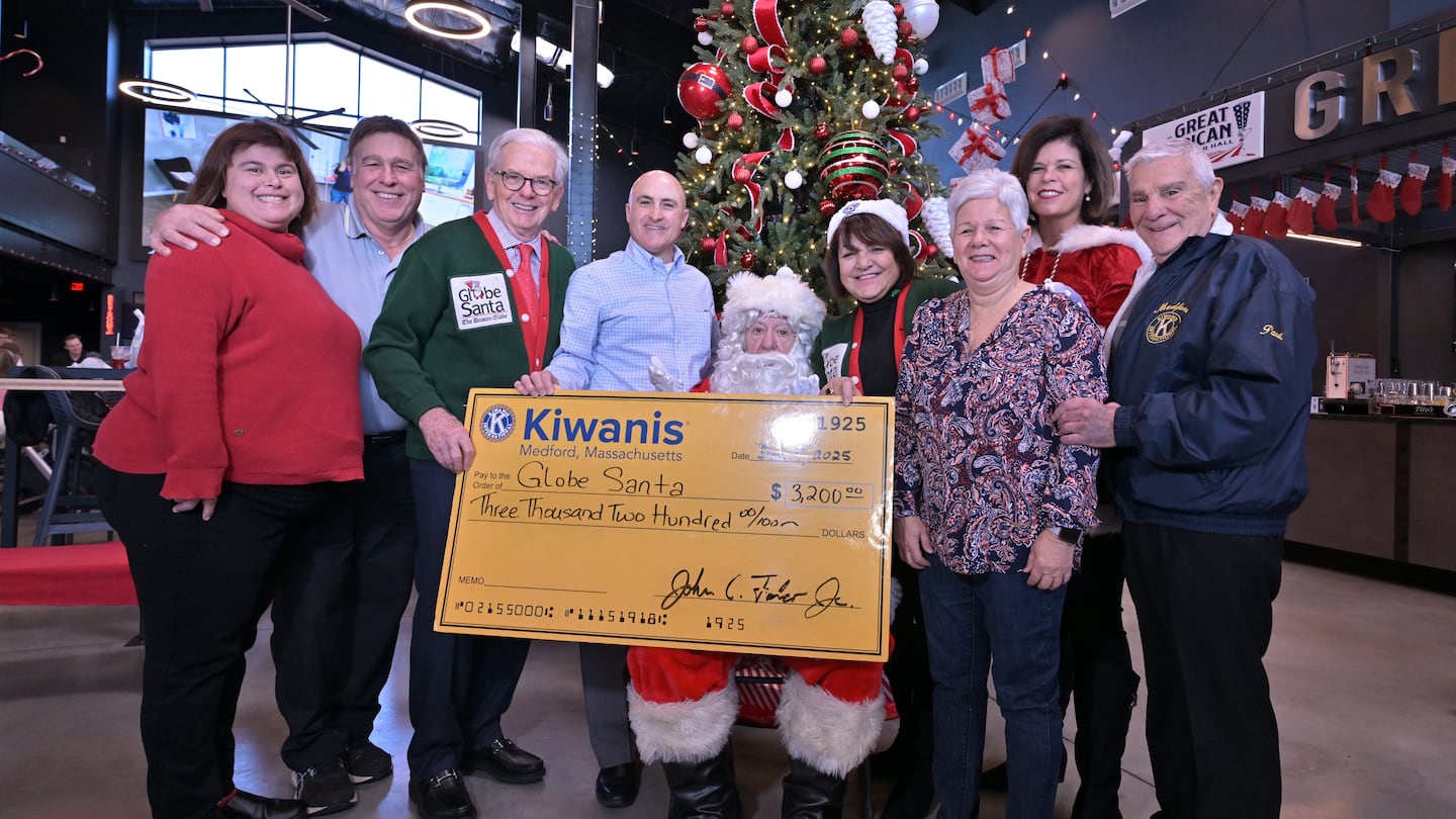 The Medford Kiwanis Club, presents Globe Santa with a check for $3,200 at The Great American Bar Hall Included in the photo are, in back row, surrounding Globe Santa are, beginning third from left, Globe Santa Executive Director Bill Connolly, Medford Kiwanis President John Falco, President elect Rita Cornelio, past president Kelly Catallo, and Medford State Rep. Paul Donato.