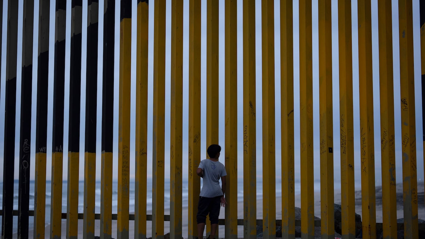 A boy looks through a border wall separating Mexico from the United States, Nov. 26, in Tijuana, Mexico.