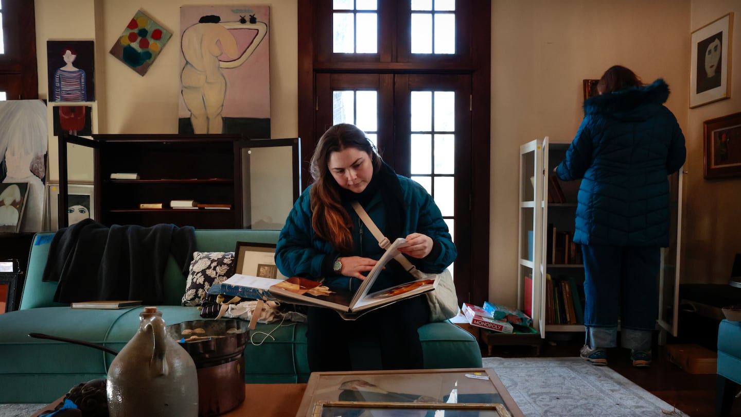 Gillian Dunn, of Boston, studies a cookbook during the estate sale at the home of celebrity chef Barbara Lynch in Gloucester, MA.