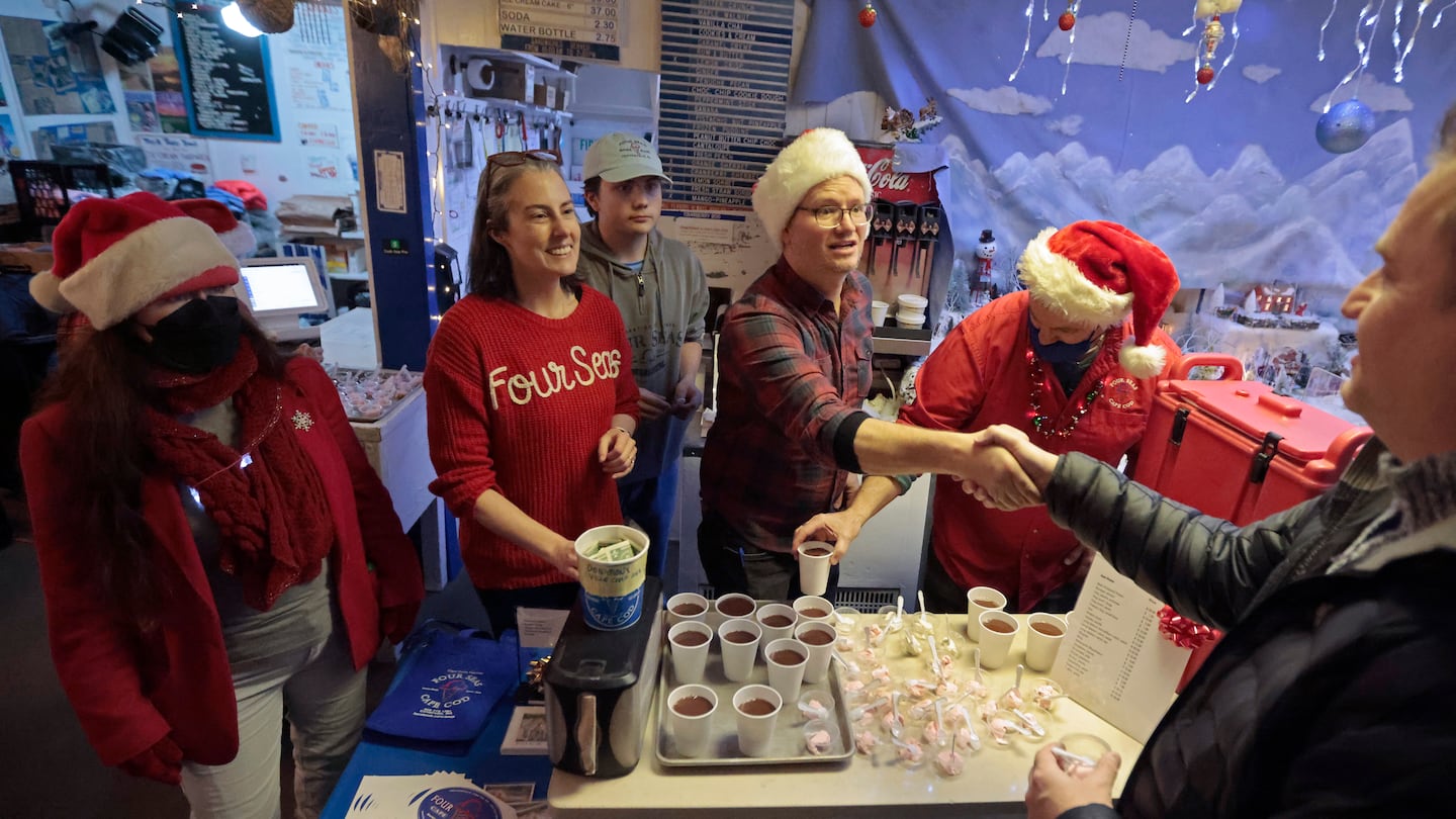 A customer greeted new owners Lesley and Josh McElhattan, with their 16-year-old son Harry in the background, on Sunday.  The McElhattans bought Four Seas Ice Cream from Peggy (left) and Douglas Warren (right), who were helping out during the Centerville Stroll.  Visitors got free hot chocolate and a tasting of peppermint stick ice cream and gingerbread ice cream.