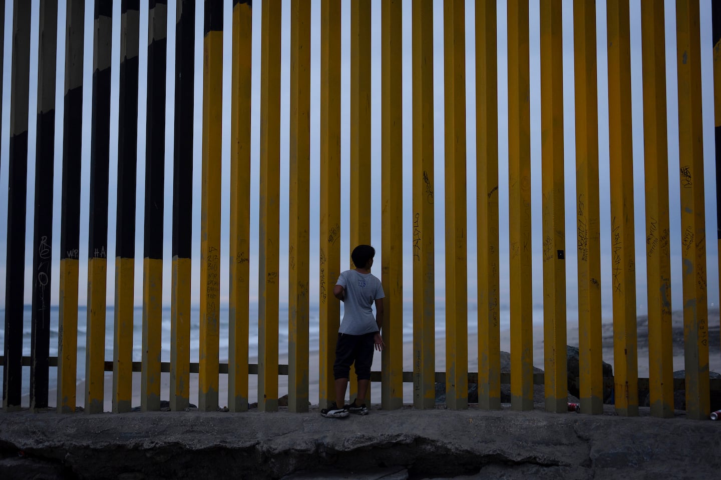 A boy looks through a border wall separating Mexico from the United States, Nov. 26, in Tijuana, Mexico.