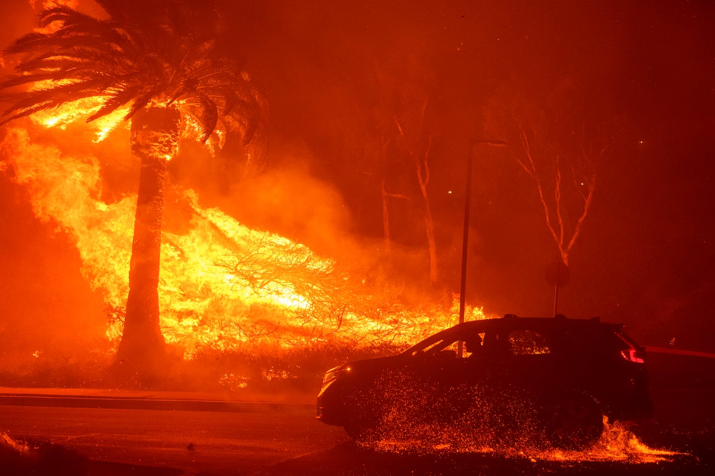 A car drove past flames from the Franklin Fire at Pepperdine University in Malibu, Calif., Tuesday, Dec. 10.