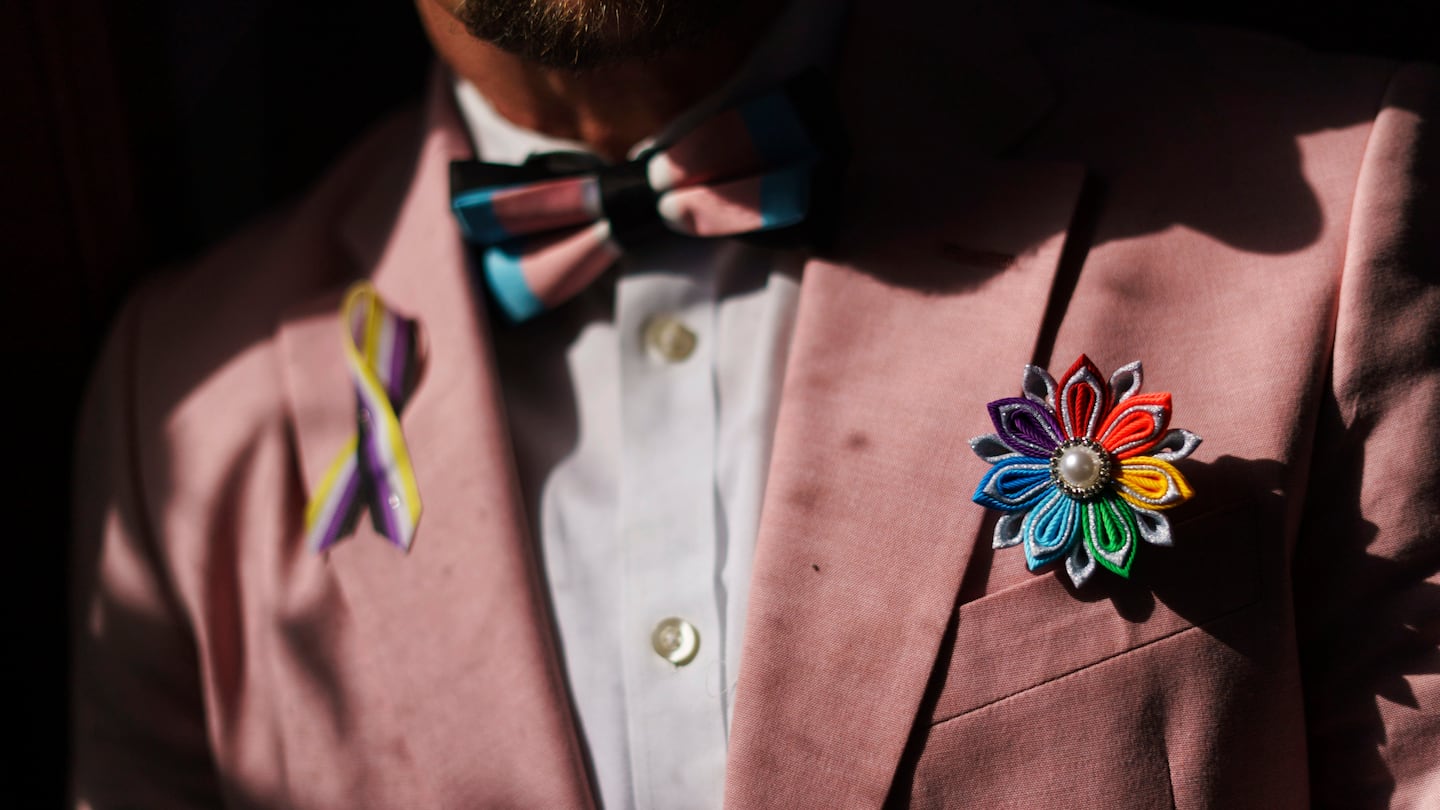 A rainbow flower sits in the jacket pocket of Scout, a transgender man who uses one name, at his home in Providence, R.I.