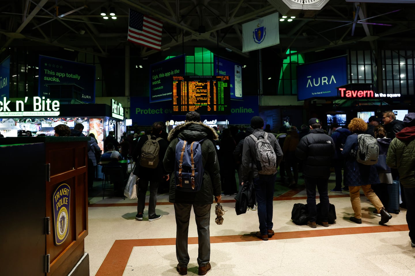 Commuters watch the train information board at South Station during the evening rush hour.