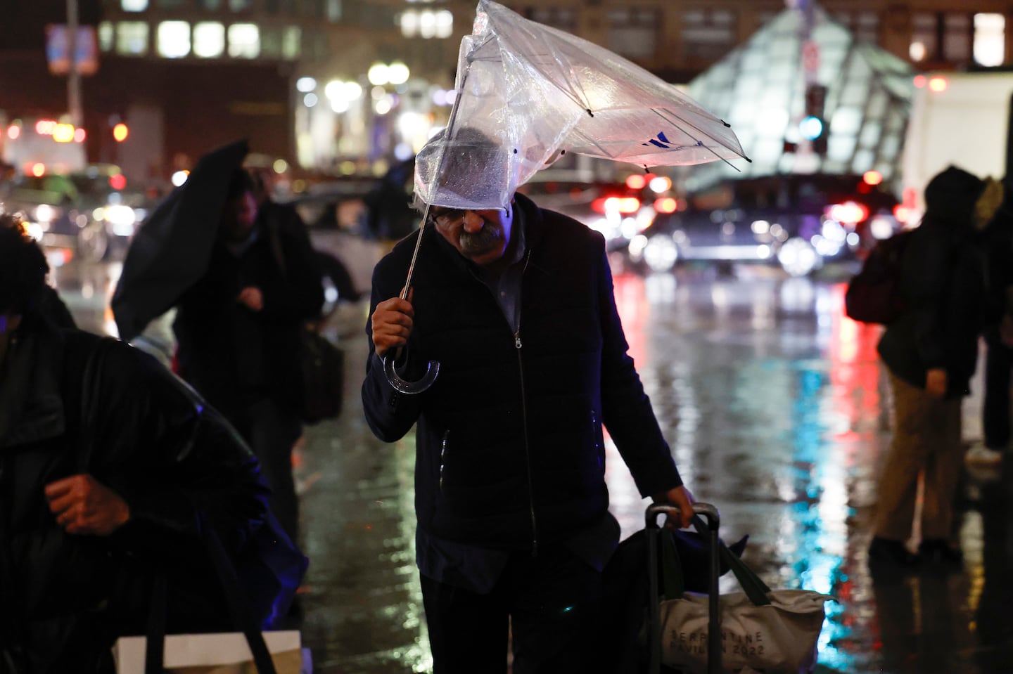 Commuters enter South Station during Wednesday's windswept rain.