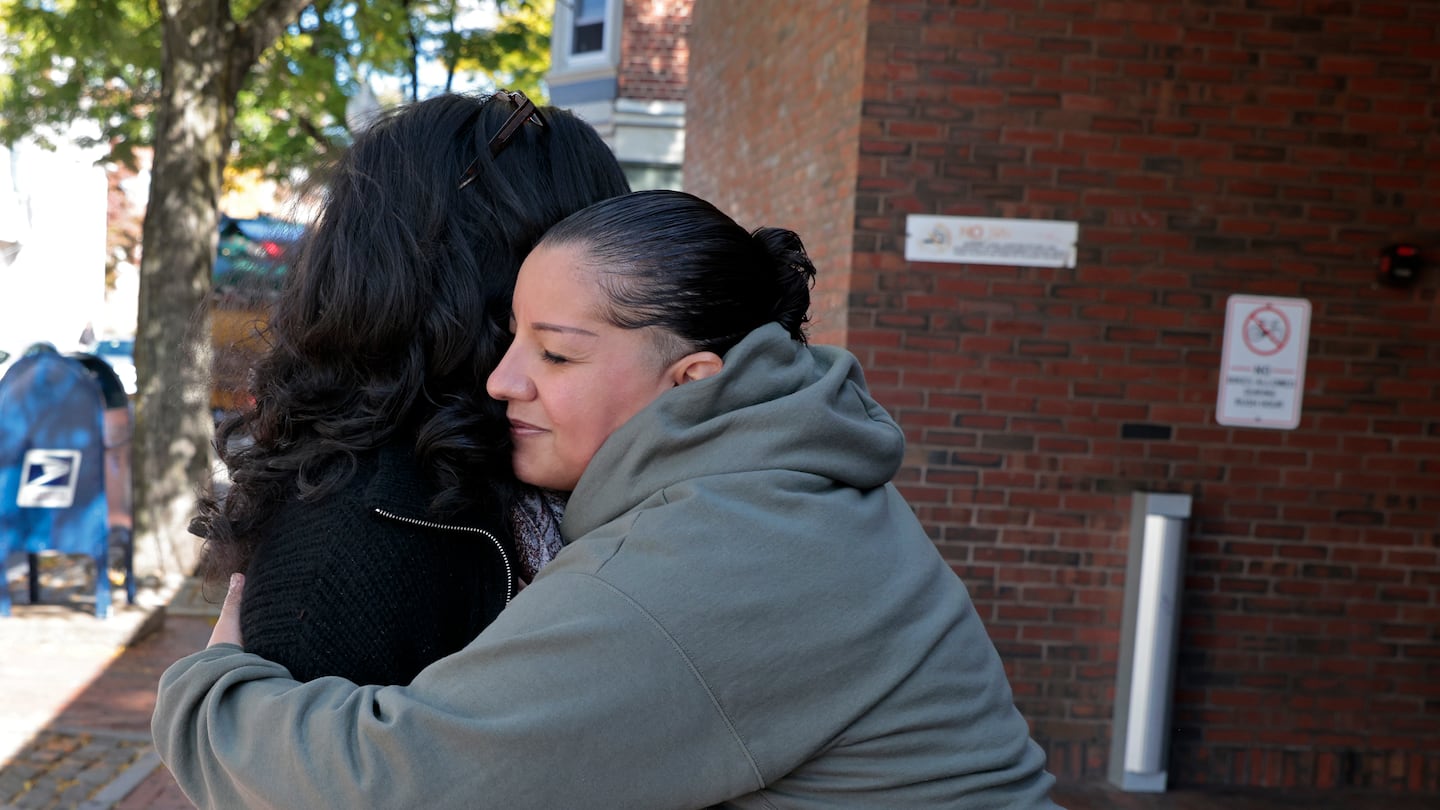 Greater Somerville Homeless Coalition outreach manager Amy Rodriguez embraces Sharon Dyer, before she enters the Davis Square T Station to head home.