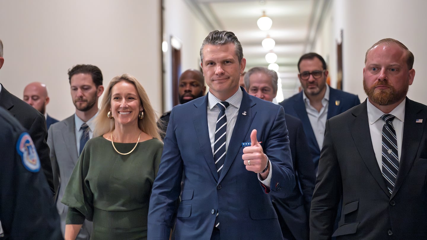 Pete Hegseth, President-elect Donald Trump's nominee to be Defense Secretary, walks with his wife Jennifer Rauchet, left, to meet with Senator Joni Ernst, a member of the Senate Armed Services Committee, at the Capitol in Washington, on Dec. 9.