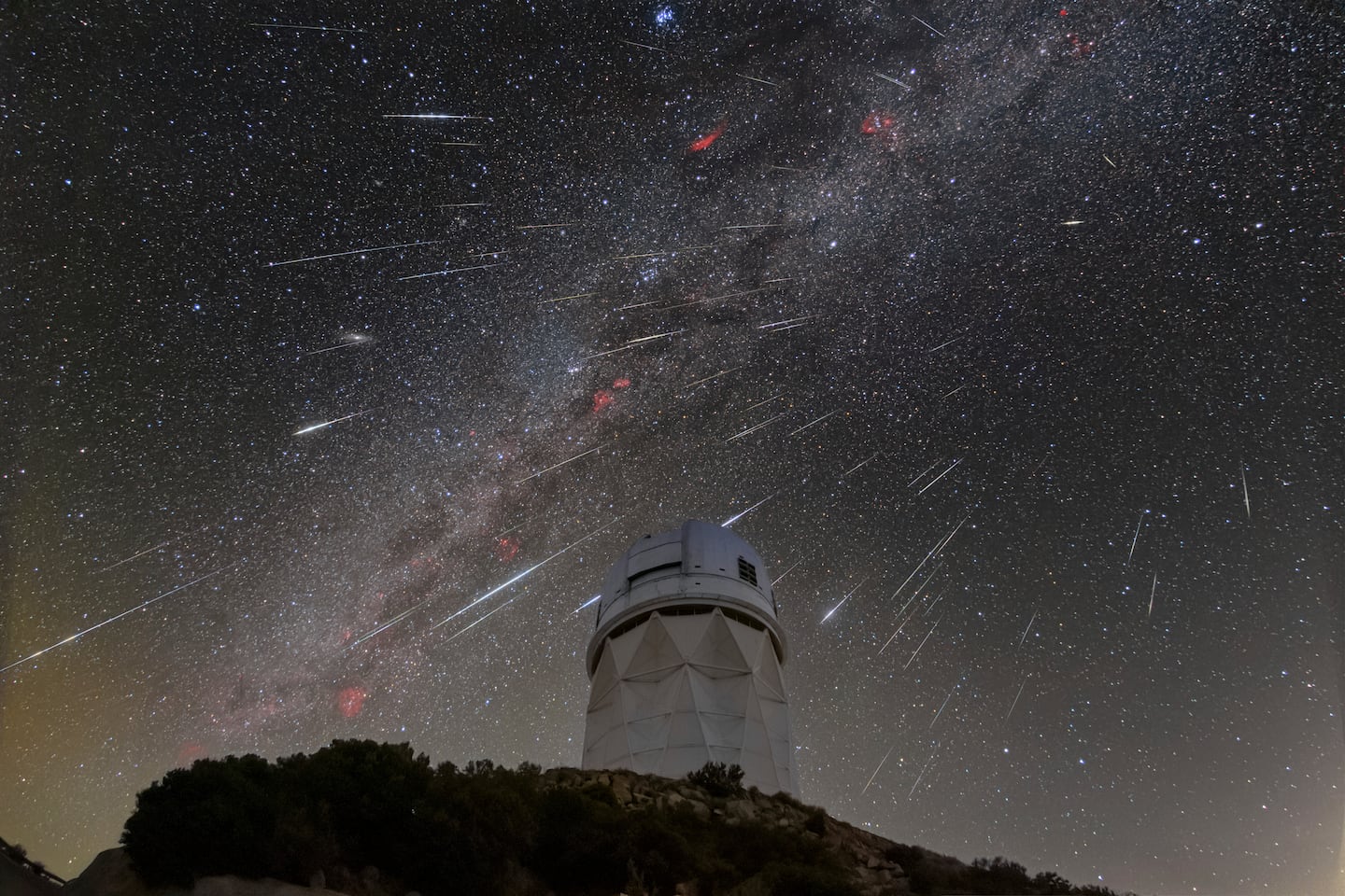 In this Dec. 14, 2023 photo provided by NOIRLab, Meteors from the Geminid meteor shower streak across the sky above the Nicholas U. Mayall Telescope at Kitt Peak National Observatory, located about 56 miles southwest of Tucson, Ariz., in the Tohono O'odham Nation.