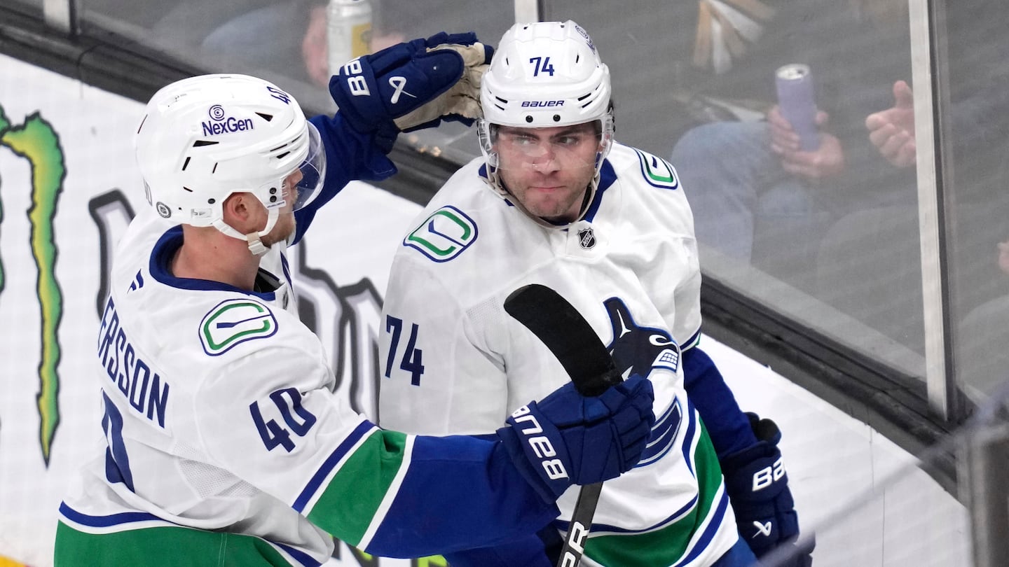 Canucks left wing Jake DeBrusk (No. 74) is congratulated by Elias Pettersson (left, No. 40) after DeBrusk's winning second-pereiod goal against Bruins goaltender Jeremy Swayman in a 2-0 victory Nov. 26 at TD Garden.